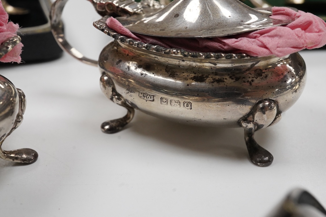 A collection of silver and white metal to include a 19th century Indian dressing table pot and cover chased with flowers, a three piece silver condiment set by Mappin and Webb with associated condiment spoon, three cased